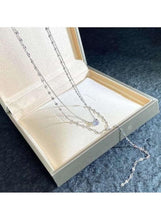 Y-shaped lariat necklace with pearl drop centerpiece coiled in jewelry display tray