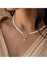 White pearl beaded necklace with gold initial A charm on a delicate chain