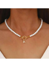 White pearl beaded necklace with gold ring clasp and initial A charm