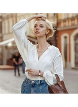White pearl necklace with single strand, worn under the collar with clasp