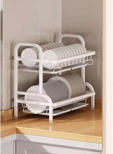 2-tier dish drying rack on counter, white frame with plate rails and cutlery cups