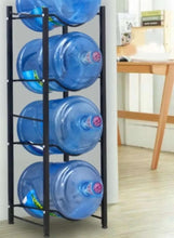 Black vertical bottle rack with four blue water jugs in a front view.