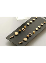 Gold stud earrings set with geometric mix, including rings and bars on card