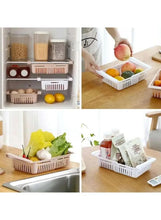 Refrigerator storage organizer bin with divider, used to hold produce and pantry items