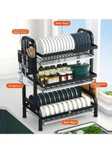 Black dish drying rack with utensil holder, drain board, and stacked plate and bowl tiers