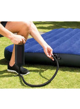 Black hand air pump with flexible hose and nozzle at inflatable valve