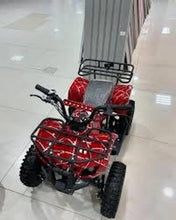Red electric ATV quad bike with rear cargo rack and gray seat, three-quarter view