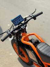Orange electric bike handlebar and frame detail with black grips and display.