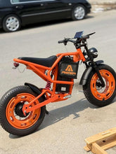 Orange electric bike with black seat, disc front brake, and rear rack.