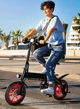 Adult riding folding electric bike with black frame and red wheel rims, front headlight on