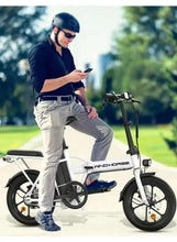 White folding electric bike in outdoor use with rider, black seat and front headlight visible