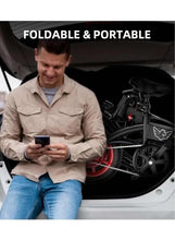Folded black electric scooter beside seated rider using a smartphone
