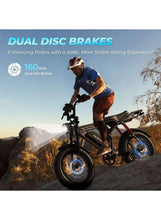 Electric fat-tire bike with rider climbing terrain, front fork and rear shock visible