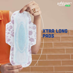 Hand holding an extra long floral winged pad showing absorbent core Whisper Choice sanitary pads XL