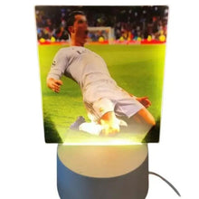 White desk lamp with glowing soccer player image panel and round base
