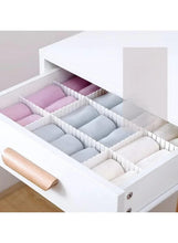 White drawer separator organizer with grid compartments for neatly sorting items in a tray.