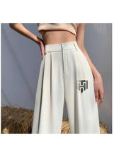White pleated wide-leg pants with high waist and belt loops, logo on side