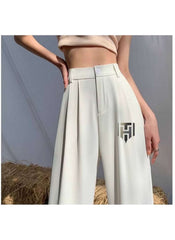 White ice silk wide leg pants by Huitich with high waist and pleated front detail