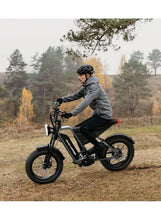 Electric fat tire mountain bike with front and rear suspension, rider on trail