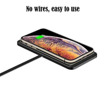 Black wireless car charger pad with charging coil and smartphone on top
