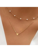 Gold-tone layered necklace with faux pearl beads and heart pendant on chain
