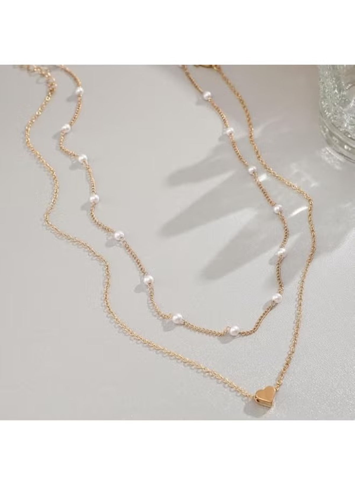 Double layer gold necklace for women featuring delicate pearls and a heart pendant