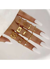 Stylish women's gold fashion ring set displayed on manicured hands with white nails