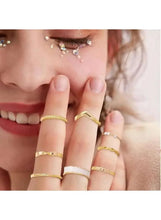 Gold-tone and white bead ring set on fingers, stacked minimalist rings