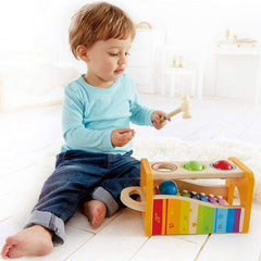 Child playing with Huitich wooden music set for kids featuring colorful xylophone and percussion instruments