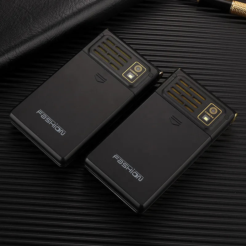 Two closed Mumzar black dual SIM flip phone for seniors with camera gold accents and speaker grills