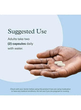 Hand holding two white vegetarian capsules for Youtheory ashwagandha use